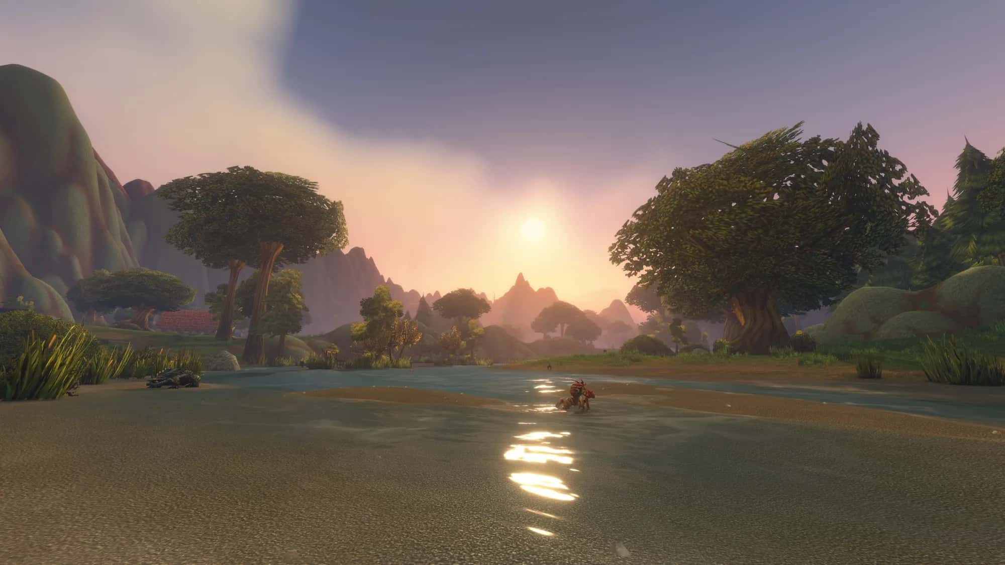 A river at sunset between wooded hills with small creatures on the shore